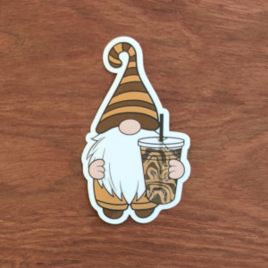 A gnome in dark and light brown striped hat holding an iced coffee.