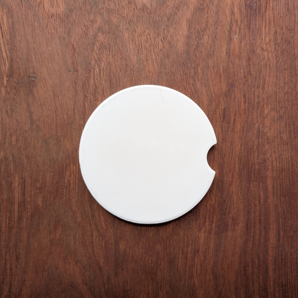 The back of a white ceramic car coaster.