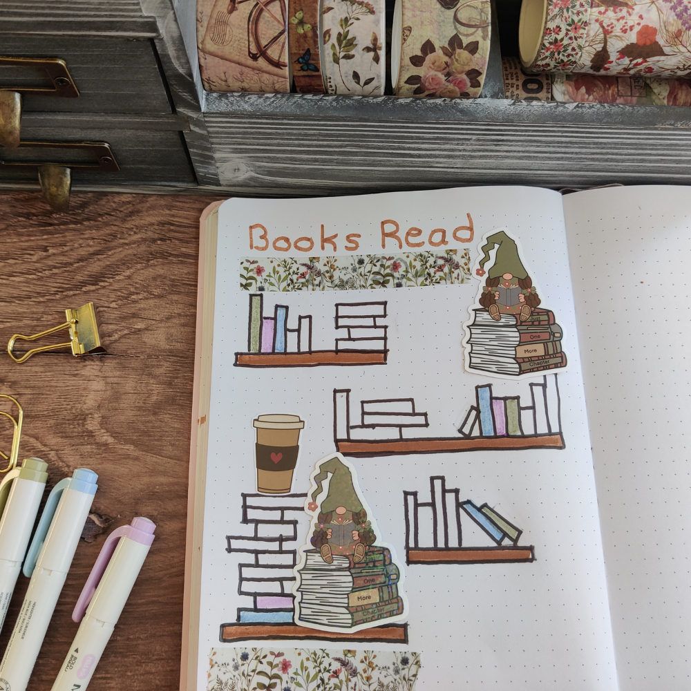 A journal opens to a page that reads " Books Read. There are 2 reading girl gnome stickers on the page.