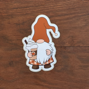 A gnome in an orange hat holding a pumpkin coffee sticker.